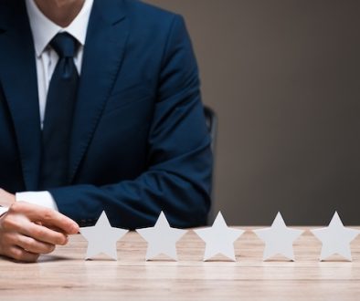 selective focus of man in suit touching star isolated on grey, quality concept