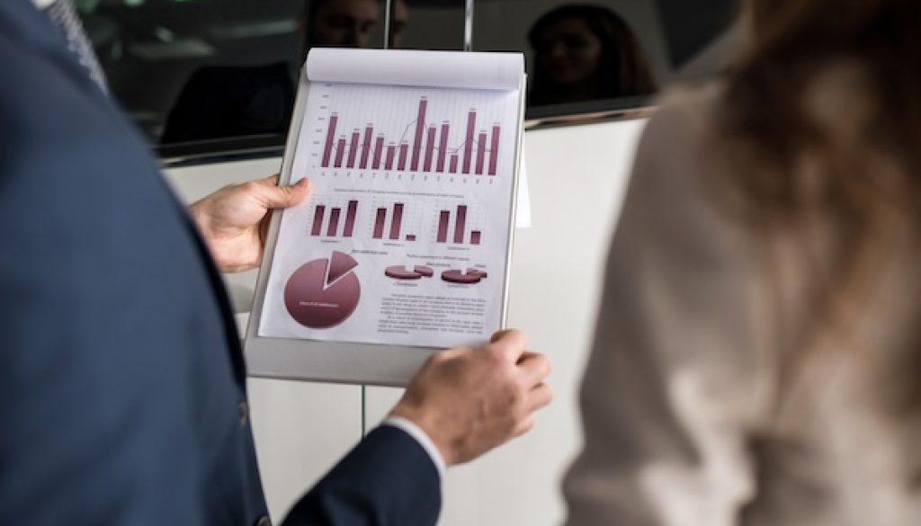 Car Salesman Holding Graphs